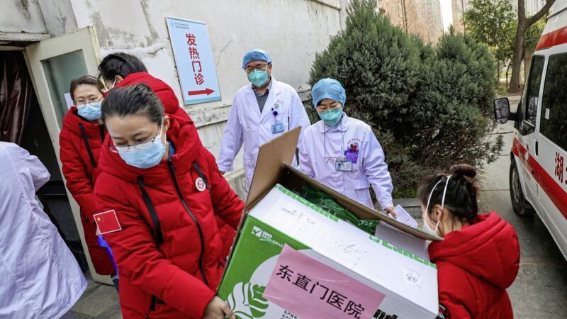 Doctors watch as donated medical supplies from Beijing are unloaded at a hospital in Wuhan in central China's Hubei Province during the early stages of the Covid-19 pandemic. Picture by Chinatopix via AP