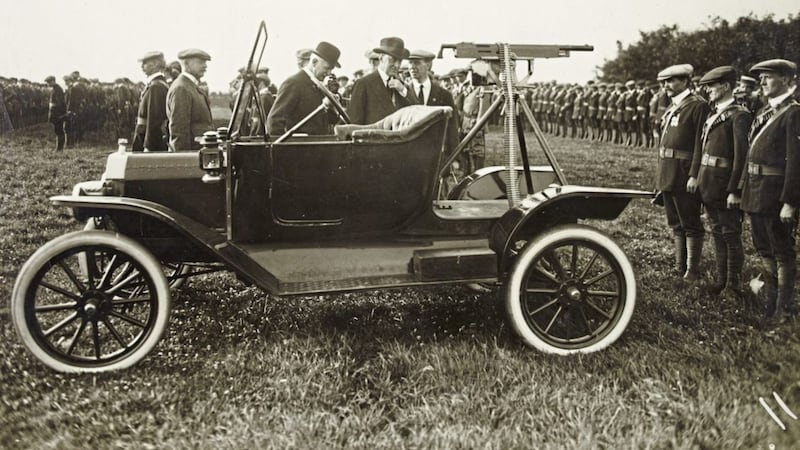 Ulster Unionist leader Sir Edward Carson inspects a Colt Browning machine gun at an Ulster Volunteer Force rally 
