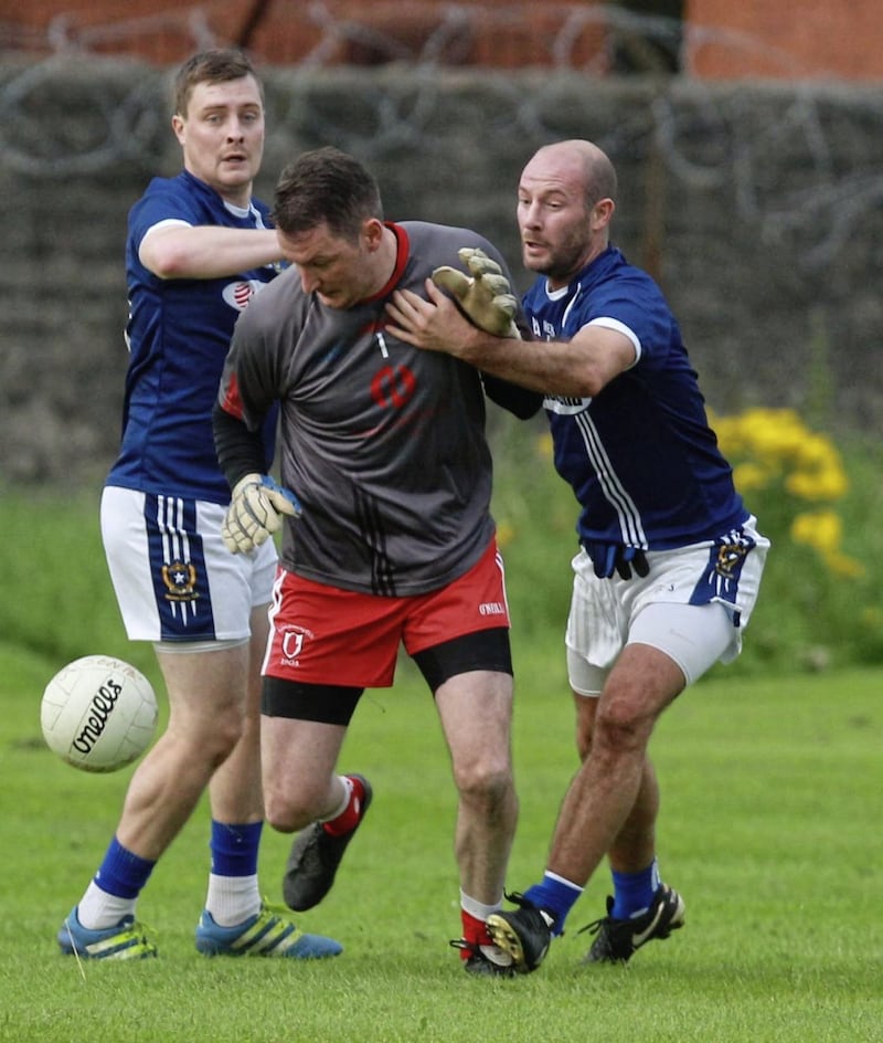 Lamh Dhearg's John Finucane and Naomh Gall's duo Conor McGourty and Kieran McGourty. Picture by Matt Bohill.