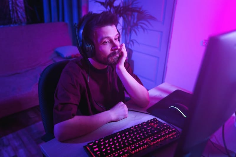 Man playing a computer game looks bored.