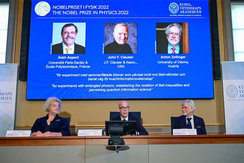Alain Aspect, left to right on the screen, John F Clauser and Anton Zeilinger 