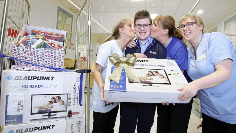 Mark McGoldrick, from Enniskillen, gets a kiss from nurses Carol |Morris, Gillian Parker and Catherine O&#39;Toole after he presented the RVH children&#39;s unit with televisions and DVDs. Picture by Cliff Donaldson 