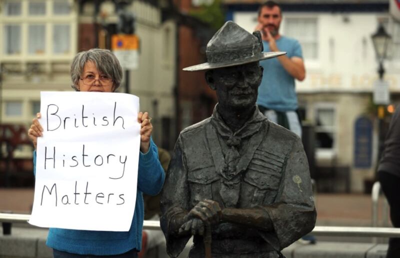 A person with a sign protesting 'British History Matters' alongside the statue of Robert Baden-Powell on Poole Quay in Dorset. Picture by Andrew Matthews, Press Association