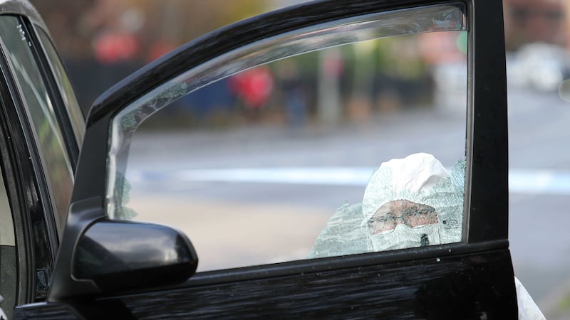 A forensic investigator examines a car in west Belfast where a man was shot in the head on Thursday. Picture by Mal McCann 