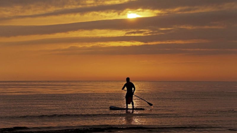 A paddle boarder enjoys the sunrise at Helen's Bay, Co Down. Picture by Mal McCann