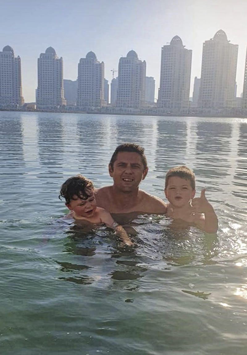 Ryan Bradley enjoying the sun with sons Finlay and Alfie in front of the Doha skyline. 
