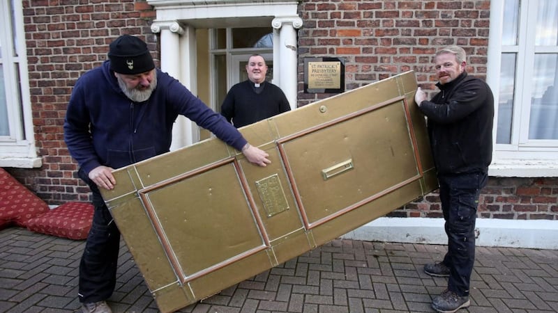 Fr Tony McAleese oversees the removal of the iconic brass door from St Patrick&#39;s Presbytery in Donegall Street, the door will be refurbished and put back in place later in the week. Picture by Mal McCann 