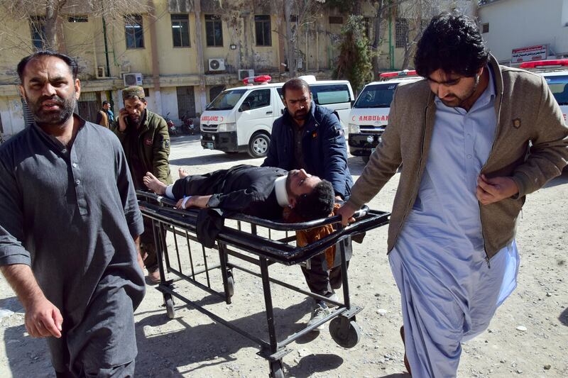 Workers and volunteers transport an injured victim from Pashin district’s bomb blast upon arrival at a hospital in Quetta, Pakistan (Arshad Butt/AP)
