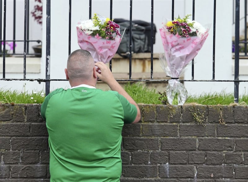Flowers being left at the scene where 57 year old Kieran Wylie was shot dead in Lenadoon, west Belfast. . 