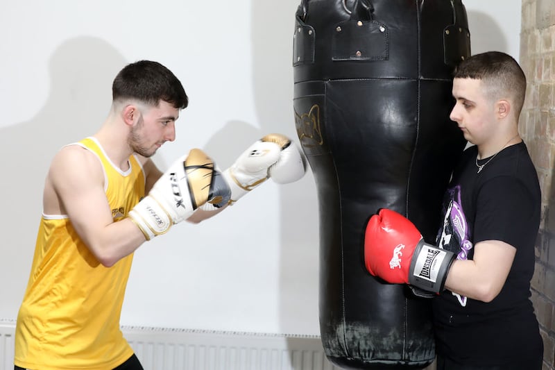 Alex McKeaveney holds the bag for Ben Ferran during a session at Clonard boxing club. Picture by Declan Roughan