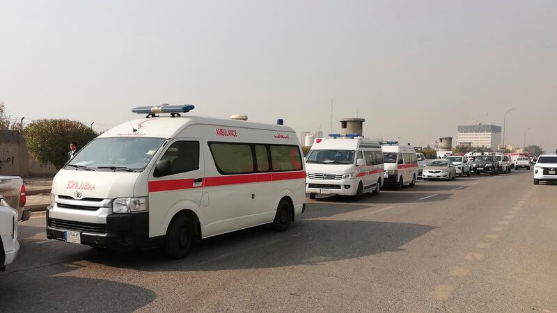 Ambulances line up in front of a headquarters of the Popular Mobilisation Force after it was hit by an airstrike in Baghdad on Thursday (Hadi Mizban/AP)