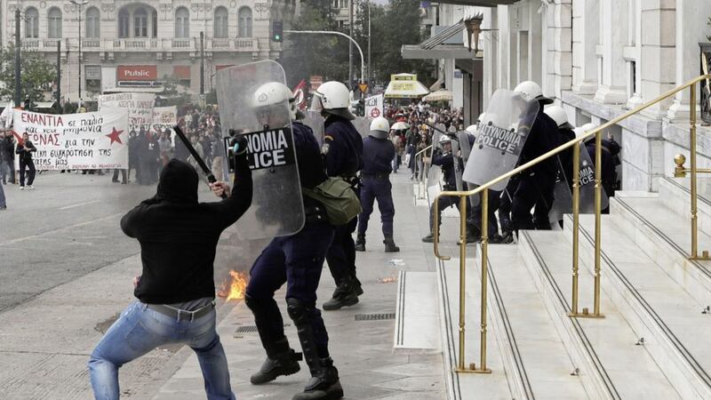 A protester uses a hammer to attack riot police officer during clashes at a nationwide general strike demonstration in Athens Picture by Thanassis Stavrakis/AP 