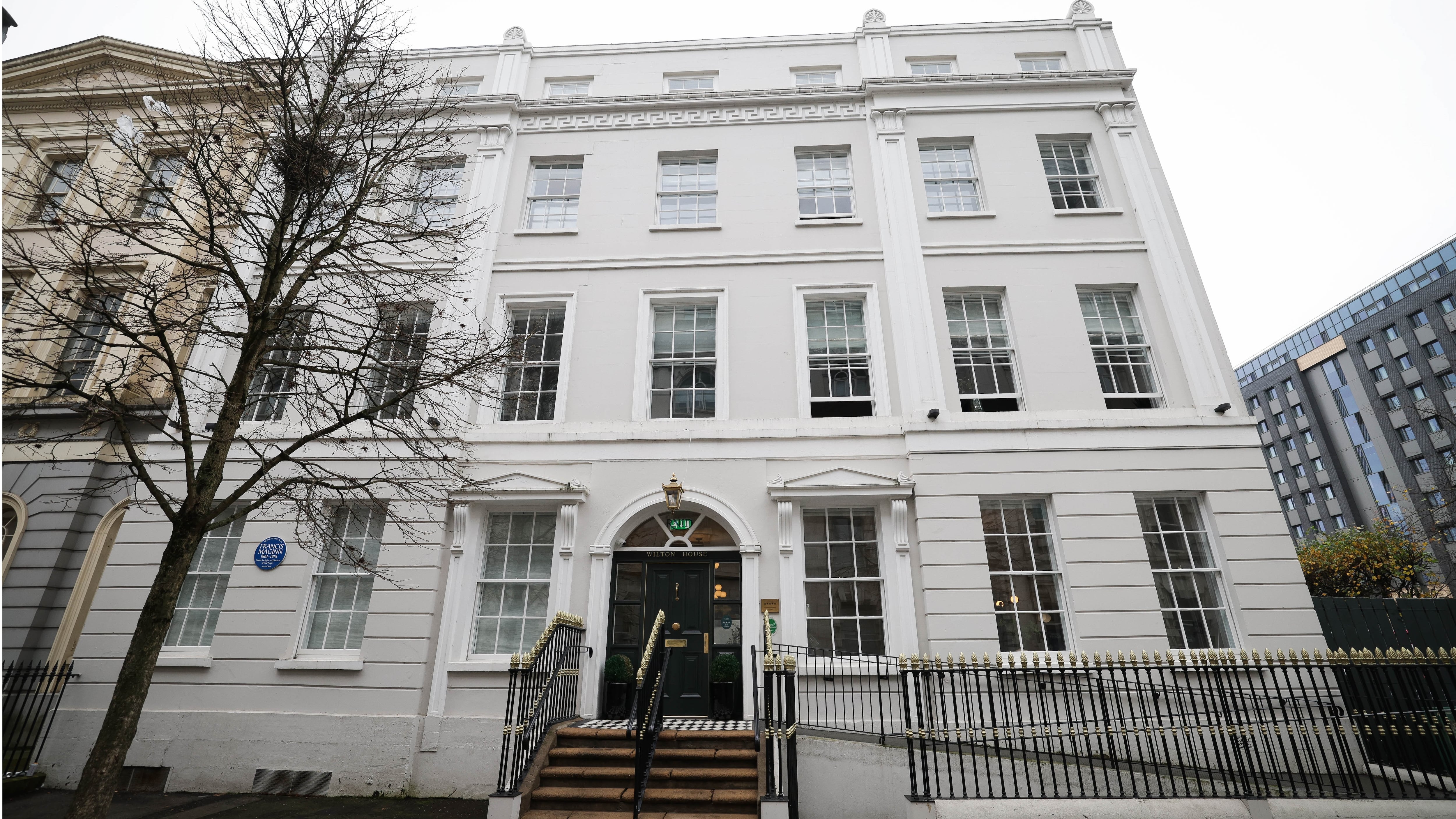 Exterior frontage of a white four storey listed Georgian era townhouse.