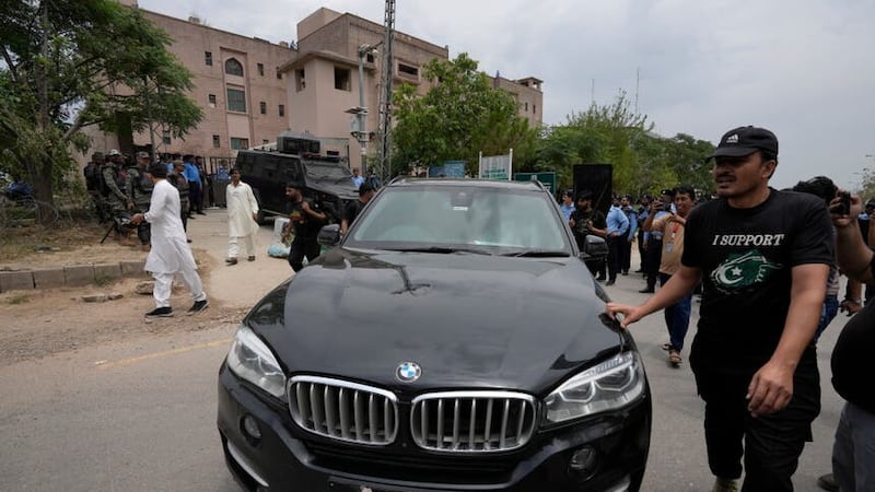 Security personnels clear way for a vehicle carrying the Pakistan’s former leader Imran Khan arrives to appear in a court, in Islamabad (AP)