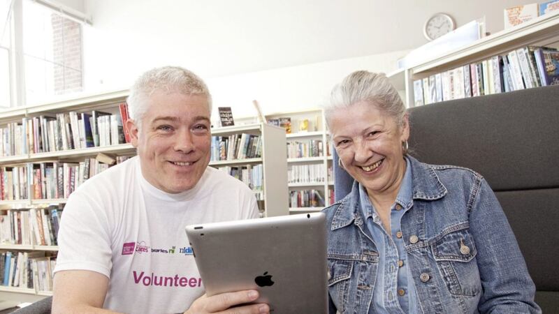 Civil servant Robert Browne provides a Silver Surfers&rsquo; Day IT training session to Sandra Eames from Belfast at Ormeau Road library 