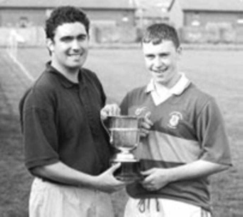 Irish News Sports Editor John Haughey presents Rossa captain Kris Morris with the Irish News trophy after his side took victory in Saturday&rsquo;s Ulster minor hurling sevens competition &nbsp;