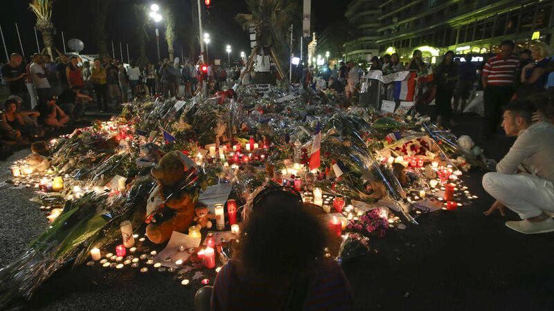 Flowers and tribute candles are laid out near the site of the truck attack in Nice last month. Picture by Luca Bruno/AP 