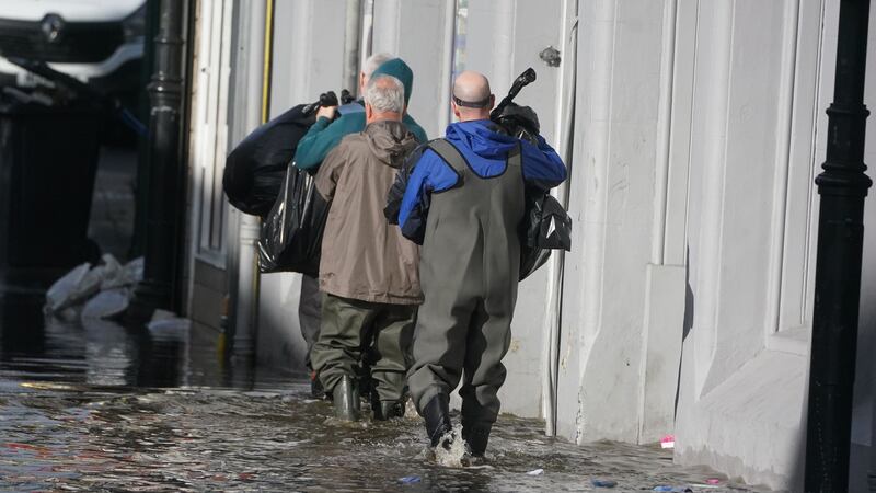 People clear out damaged shops in Sugar Island, Newry Town, Co Down, which has been swamped by floodwater as the city’s canal burst its banks amid heavy rainfall. Dozens of businesses were engulfed in the floods, with widespread damage caused to buildings, furnishings and stock (Brian Lawless/PA)