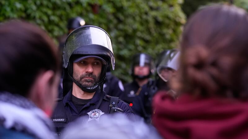 A police officer stands guard blocking pro-Palestinian protesters from returning to their encampment as the encampment is dismantled at the University of Chicago (Charles Rex Arbogast/AP)