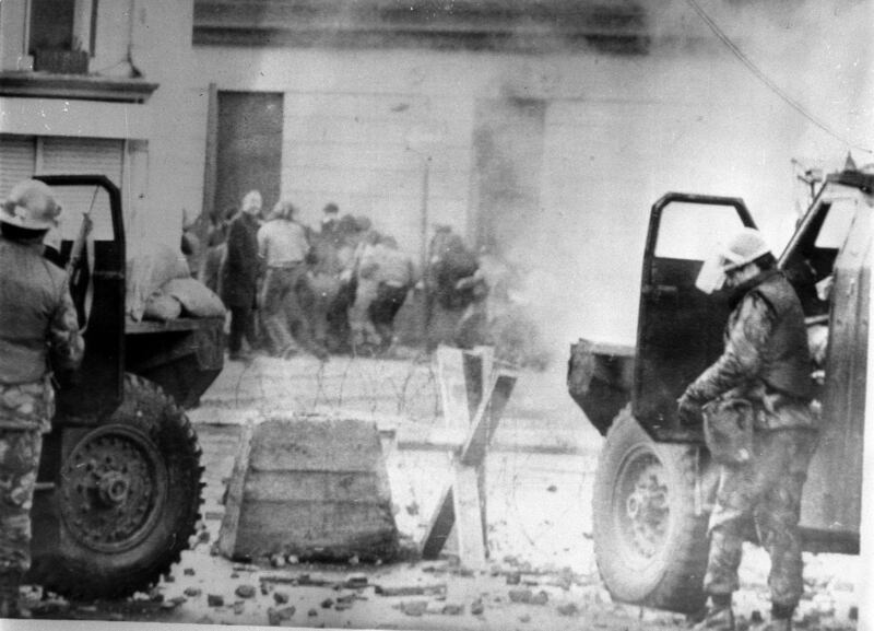 Soldiers take cover behind sandbagged armoured cars