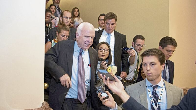 Sen John McCain, front left, is pursued by reporters on Capitol Hill, Washington after casting a &#39;no&#39; vote on a measure to repeal parts of former president Barack Obama&#39;s health care law PICTURE: Cliff Owen/AP 