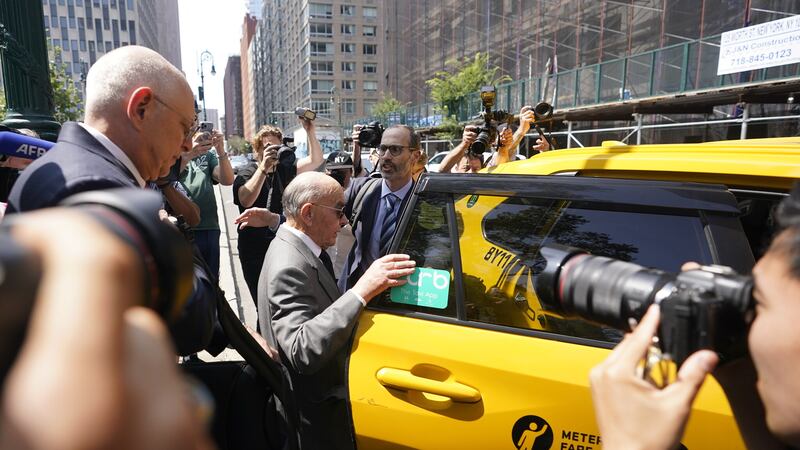 Tavistock founder Joe Lewis, centre, is surrounded by photographers as he leaves Manhattan federal court (Mary Altaffer/AP)