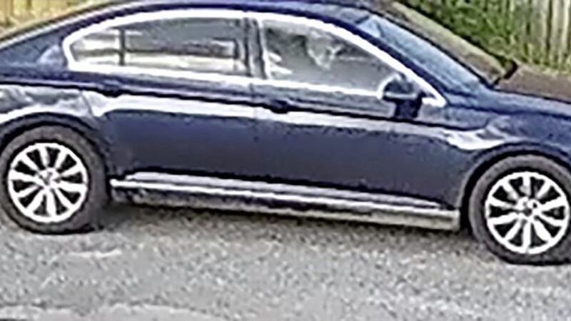 The blue Volkswagen Passat being driven by a man in a baseball cap 