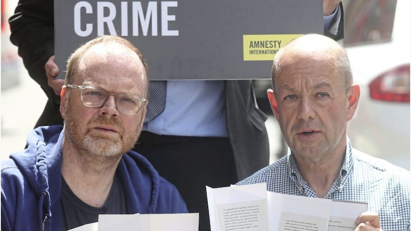 Trevor Birney and Barry McCaffrey with messages of support in the wake of the police action. Picture by Hugh Russell
