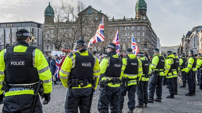 Police in riot gear form a line at Belfast City Hall as protesters taking part in the flag protest arrive