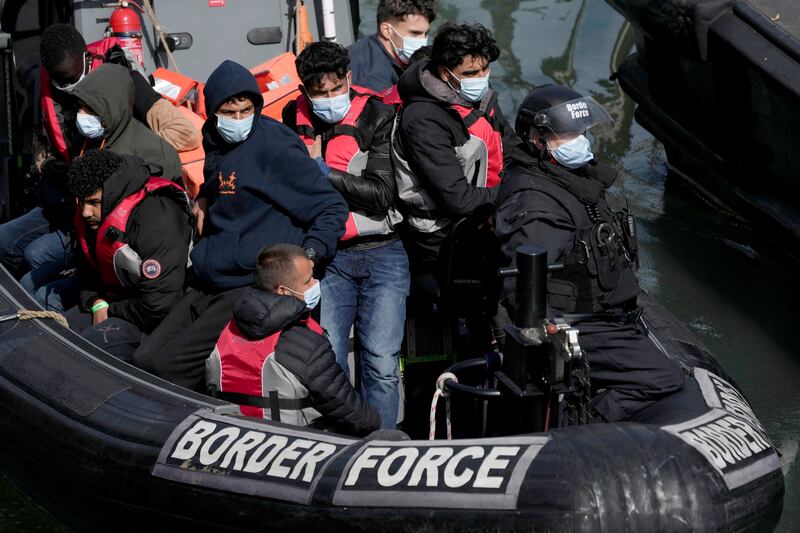People thought to be migrants, who undertook the crossing from France in small boats and were picked up in the Channel, arrive to be disembarked from a small transfer boat which ferried them from a larger British border force vessel that did not come into the port, in Dover, south east England (Matt Dunham/AP)