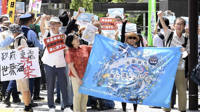A protester holds a sign during a rally against the treated radioactive water release from the damaged Fukushima nuclear power plant, in front of TEPCO headquarters in Tokyo (Norihiro Haruta, AP)
