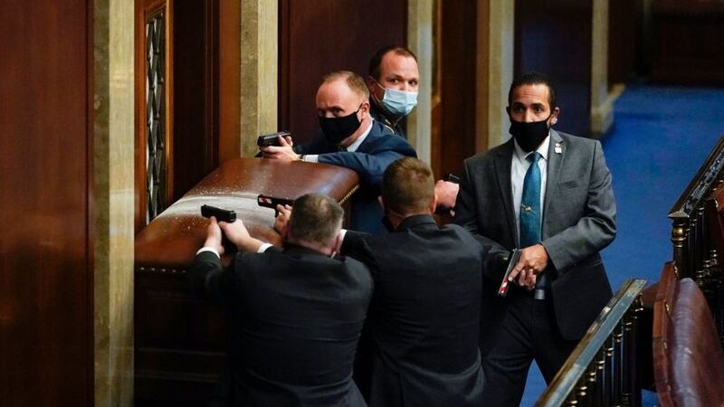 US&nbsp;Capitol Police with guns drawn stand near a barricaded door as Trump supporters try to break into the House Chamber at the US&nbsp;Capitol in Washington DC on January&nbsp;6 2021. Picture by&nbsp;Andrew Harnik, AP&nbsp;