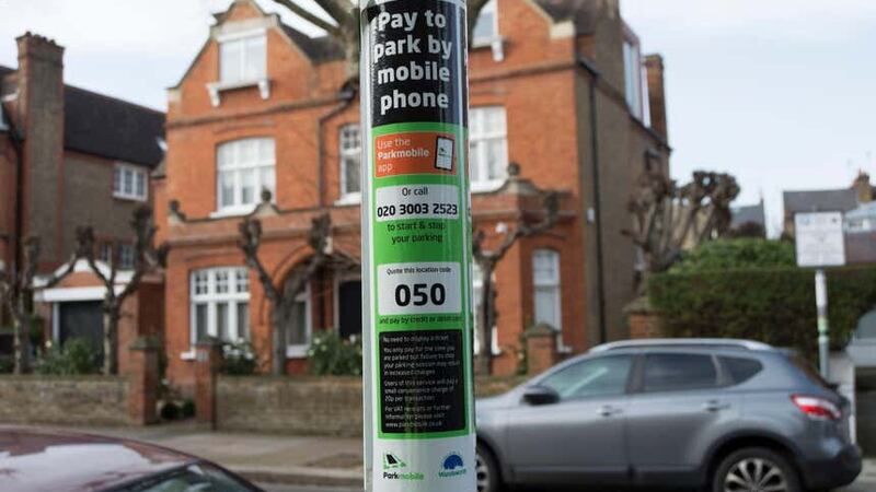 A notice with instructions on how to use a mobile to pay for parking is displayed on a lamppost in Putney, south-west London (Alamy/PA)