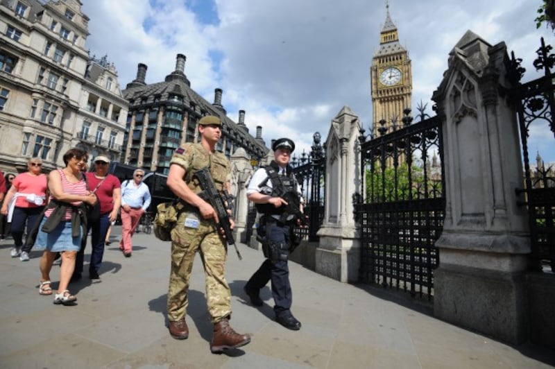 A member of the army joins police officers outside the Houses of Parliament