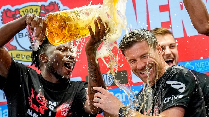 Leverkusen’s head coach Xabi Alonso, centre, is sprayed with beer after Bayer Leverkusen won the Bundesliga title (AP Photo/Martin Meissner)