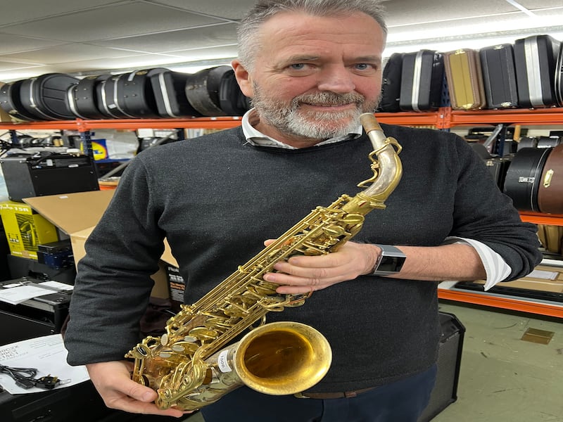 Auctioneer Jamie South with a saxophone belonging to Peter King (Gardiner Houlgate/PA)