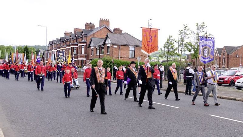Marshalled by PSNI officers, an Orange Order parade passes off peacefully through Ardoyne in north Belfast 