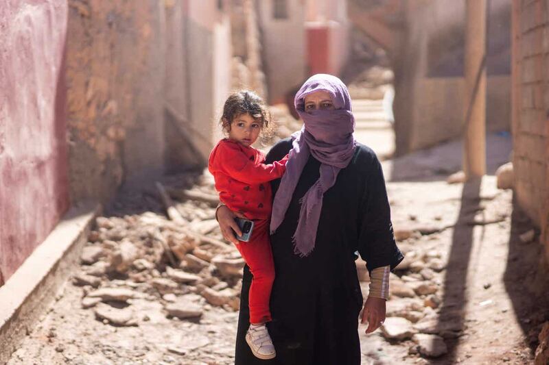 A woman and her daughter stand outside her home after the earthquake in Moulay Ibrahim village