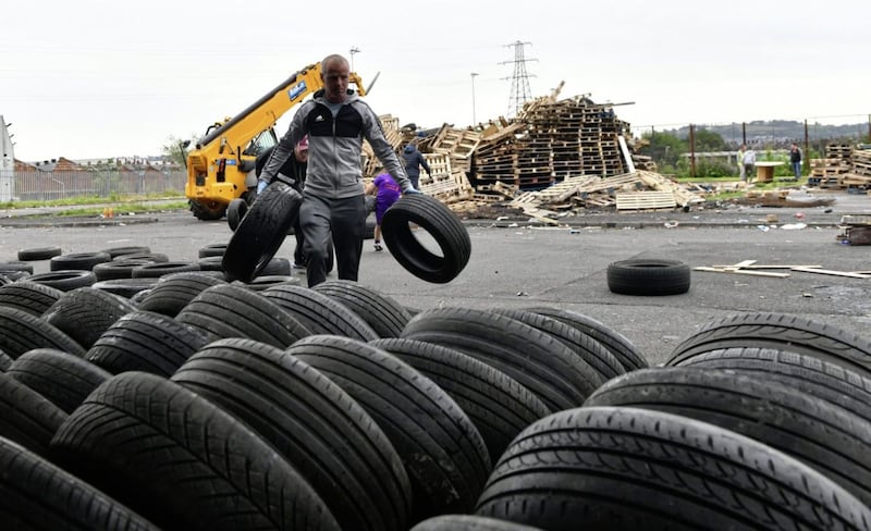Bonfire builders at the Avoniel Leisure Centre site voluntarily remove tyres from their bonfire on Monday. 