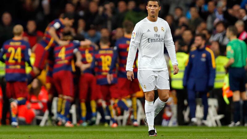 Real Madrid's Cristiano Ronaldo is left looking shell shocked as Barcelona's players celebrate their third goal during Saturday night's clash at the Bernabeu<br />Picture by PA