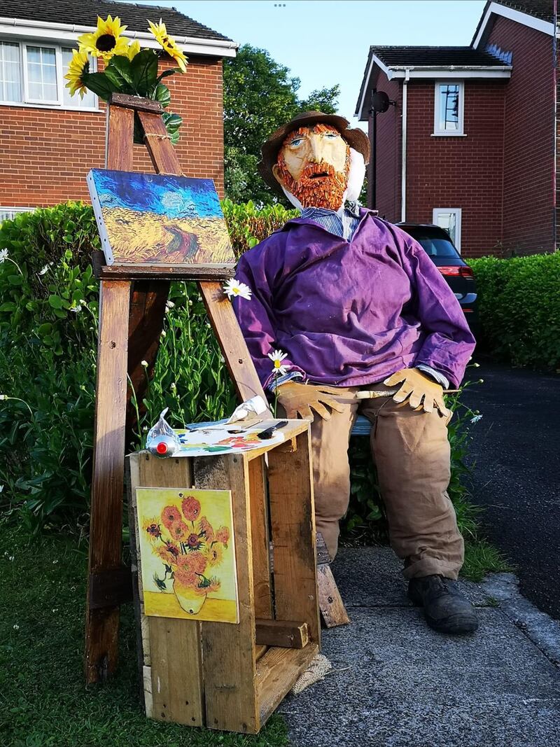 A scarecrow figure of Vincent Van Gogh with a painting table next to him