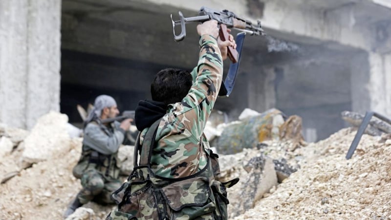 Syrian army soldiers fire their weapons during a battle with rebel fighters at the Ramouseh front line, east of Aleppo, Syria. Picture by Hassan Ammar, Associated Press