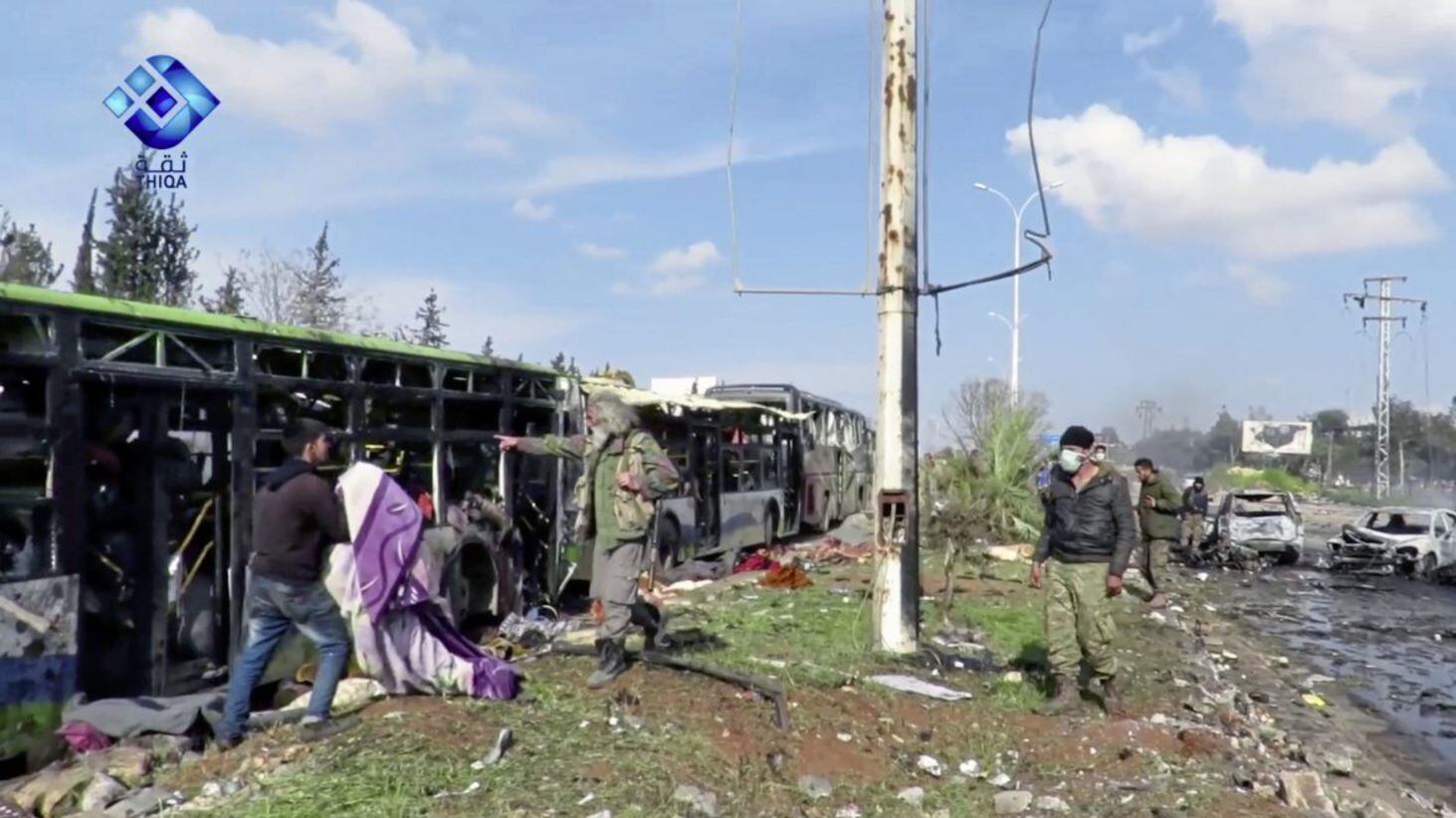 Rebel gunmen at the site of a blast that damaged several buses carrying evacuees, at the Rashideen area, a rebel-controlled district outside Aleppo city, Syria Picture: Thiqa News via AP 