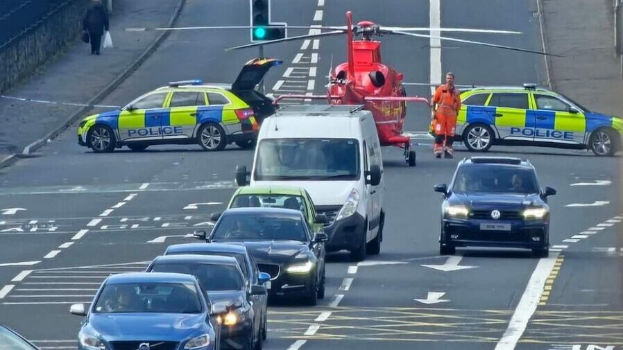 Emergency services at the scene of a crash involving a cyclist on the Stewartstown Road area of west Belfast on Friday. Picture, RNU Béal Feirste