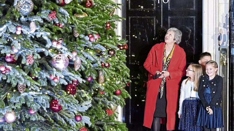 Theresa May switching on the lights on the Downing Street Christmas tree last night with some children. Picture by Dominic Lipinski/PA 