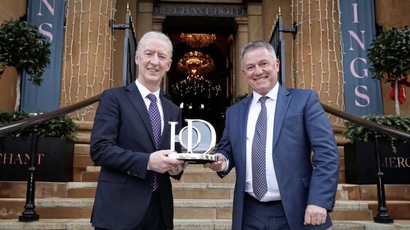 Sir Michael Ryan is presented with his award by Gordon Milligan, IoD NI chairman. 