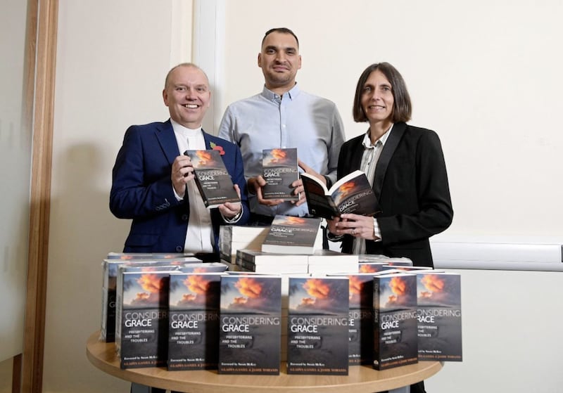 &#39;Considering Grace: Presbyterians and the Troubles&#39;, by Gladys Ganiel and Jamie Yohanis, tells the stories of ministers, victims, members of the security forces, those affected by loyalist paramilitarism, emergency responders and peace-makers. The authors are pictured with Presbyterian moderator Dr William Henry and 120 copies of the book, each representing a story told within. Picture by Michael Cooper 