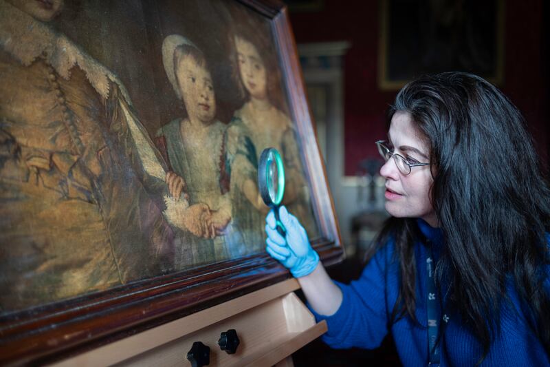 A curator inspects the recently discovered print by the 18th Century printmaker Jacob Christoff Le Blon at Oxburgh Hall in Norfolk.