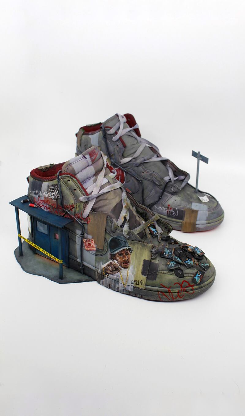 A pair of sneakers with artwork and mini sculptures on it