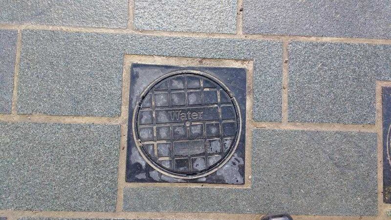 After- a street cover in Ballymena with the Irish word for water, Uisce, removed
